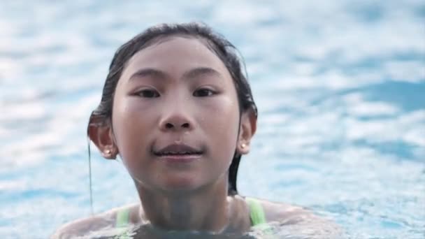 Ázsiai lány, úszás a medencében, lassú mozgás. - Felvétel, videó