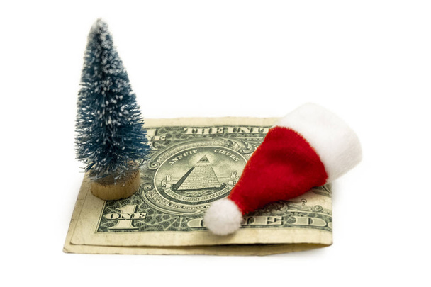 Un chapeau rouge jouet du Père Noël, un souvenir d'arbre de Noël sur la seule facture américaine. Le concept du coût de célébrer le Nouvel An ou combien il en coûte pour célébrer NY en Amérique
. - Photo, image