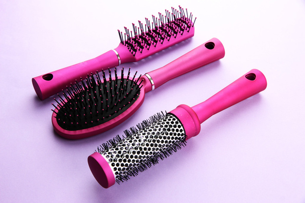 Comb brushes on purple background - Foto, afbeelding