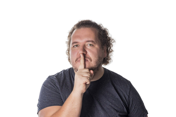 Portrét pohledný muž krčí ústa svým prstem - Fotografie, Obrázek