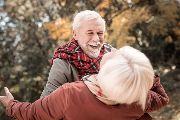 Positivo alegre anciano sosteniendo a su esposa
 - Foto, imagen