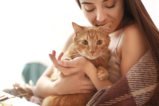 Woman with cute cat resting at home - Foto, afbeelding