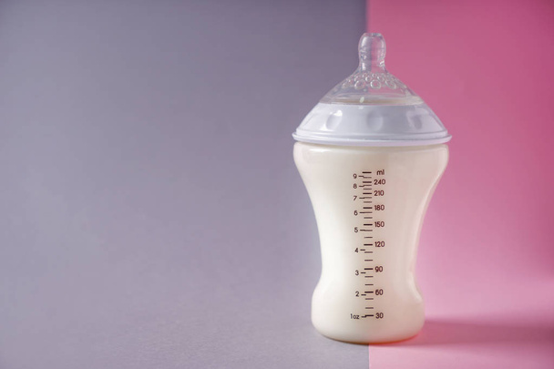 Feeding bottle of milk for baby on color background - Valokuva, kuva