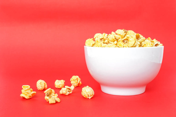 mísa popcornu bílé na červeném pozadí - Fotografie, Obrázek