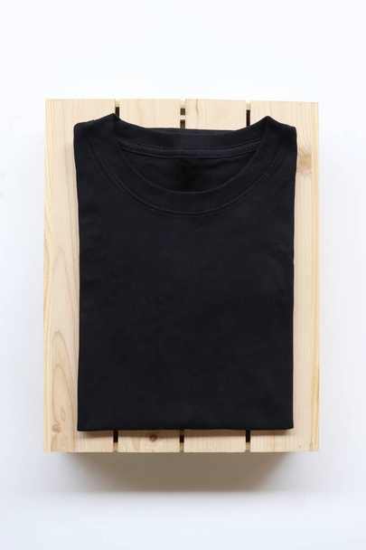 camisetas negras, grises, blancas con caja de madera y cactus. fondo rústico
 - Foto, Imagen