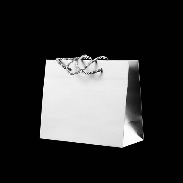 Beautiful grey gift bag. Close up. Isolated on black background. - Foto, imagen