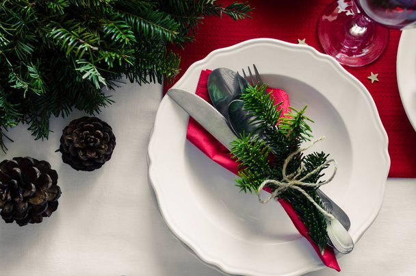 Family together Christmas celebration dinner table concept. Festive place setting for holiday dinner with natural decorations from fir tree branches and pine cones. Top view. Flat lay. - Photo, Image