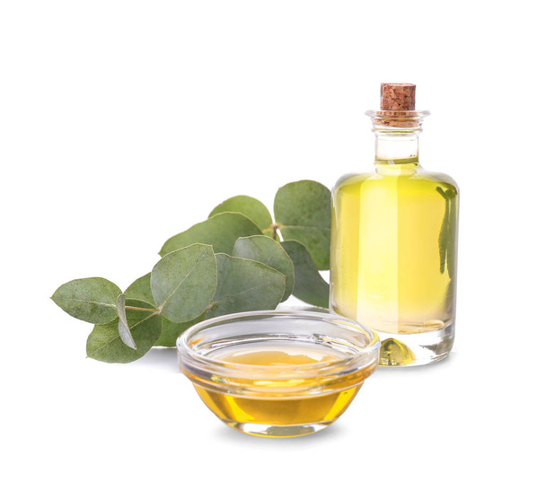 Botella y tazón con aceite esencial de eucalipto sobre fondo blanco
 - Foto, imagen
