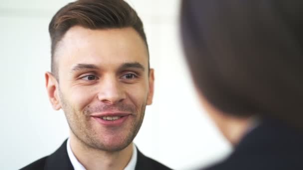 4K. Un hombre de negocios sonriente habla en la oficina con una mujer. Cara de cerca
 - Metraje, vídeo