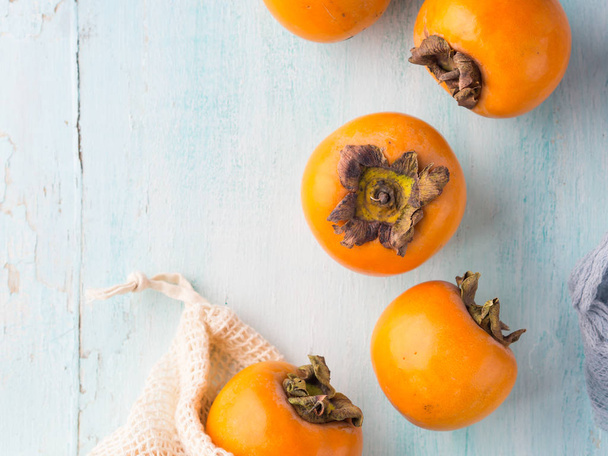 Dojrzałe persimmons na turkus tło - Zdjęcie, obraz