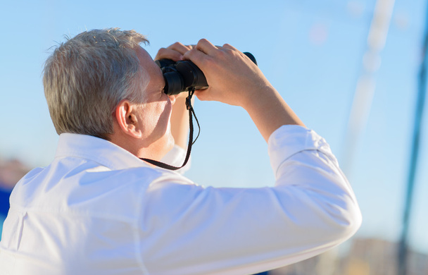 hombre maduro mirando a través de binocular
 - Foto, Imagen