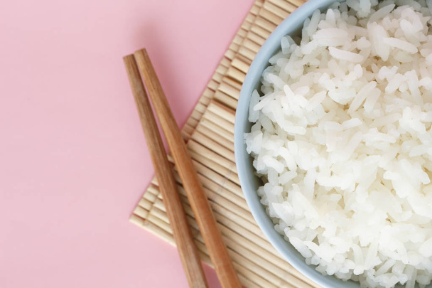 Reis in Schale auf rosa Hintergrund Rosenquarz - Foto, Bild