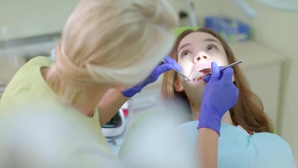 Teeth treatment in dental clinic. Dentist using dental tools to sick tooth - Footage, Video