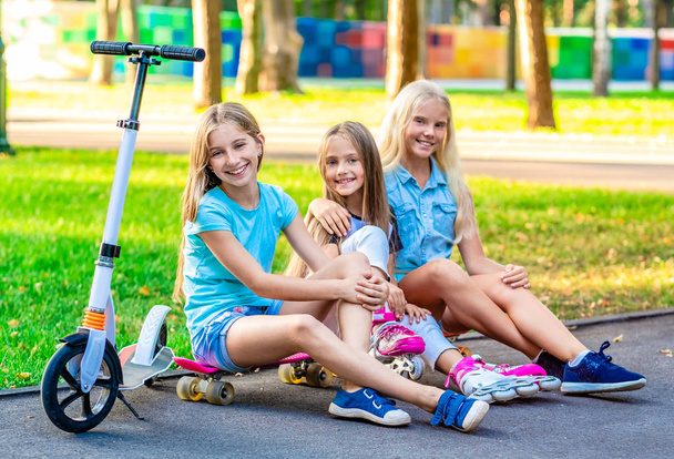 Little girls sitting in sunshine park - Fotografie, Obrázek