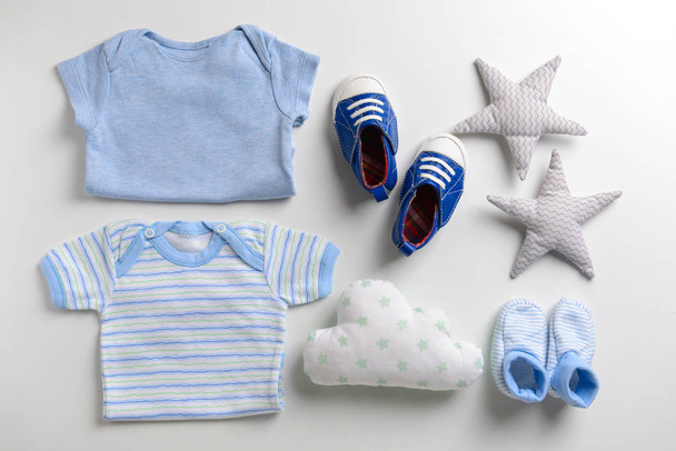 Bonito bebê roupas e brinquedos no fundo branco
 - Foto, Imagem