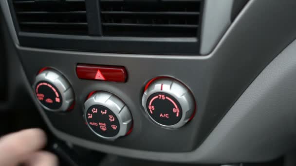 Close-up van de hand de air conditioner-knop in de auto aan te passen. Man met behulp van auto airconditioningsysteem. Dubbele airco in de auto. - Video