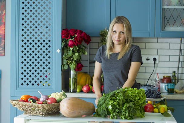 Девушка готовит здоровую пищу на кухне с овощами. Вегетарианская кухня. Молодой европеец в возрасте двадцати лет. Концепция здорового питания
. - Фото, изображение