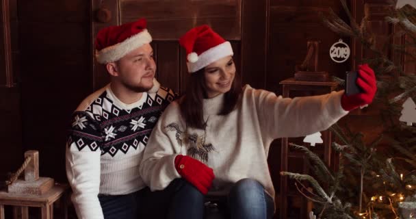 Liebendes Paar mit Weihnachtsmütze macht Selfie. - Filmmaterial, Video