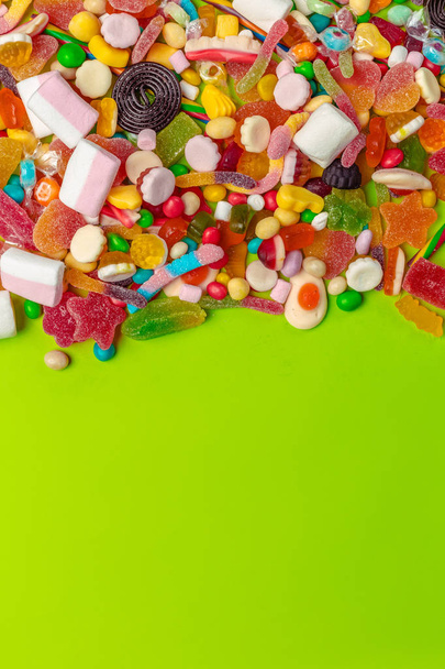 Colorful candies on green background - Фото, изображение