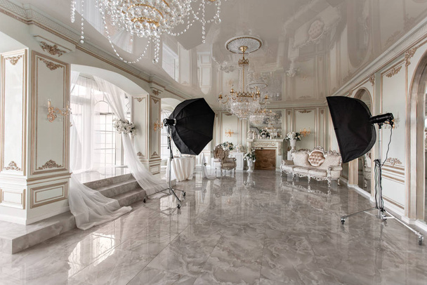 Photo Studio belső. klasszikus luxus apartmanok, egy fehér kandalló, kanapéval, nagy ablakokkal és csillár. - Fotó, kép
