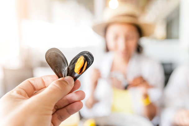 Young Woman Eating Freshly cooked Mussels - Photo, Image