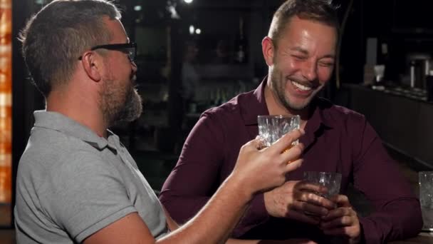 zwei Freunde lachen in die Kamera, während sie zusammen trinken - Filmmaterial, Video