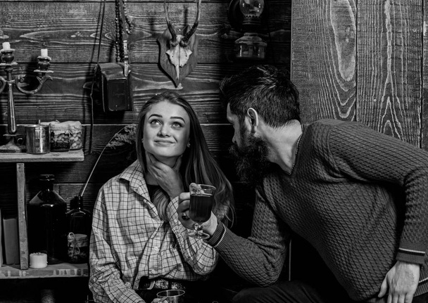 Girl and man on smiling faces enjoy cozy atmosphere with hot drinks. Couple spend pleasant evening, interior background. Family, couple in love enjoy vacation in gamekeepers house. Coziness concept - Fotografie, Obrázek