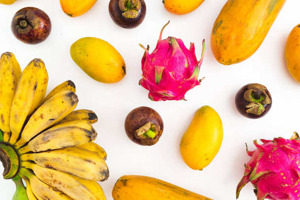 Modello di frutta di banana, papaia, mango con mangostano e frutti di drago su sfondo bianco. Piatto. Vista dall'alto. Concetto di frutta tropicale
 - Foto, immagini