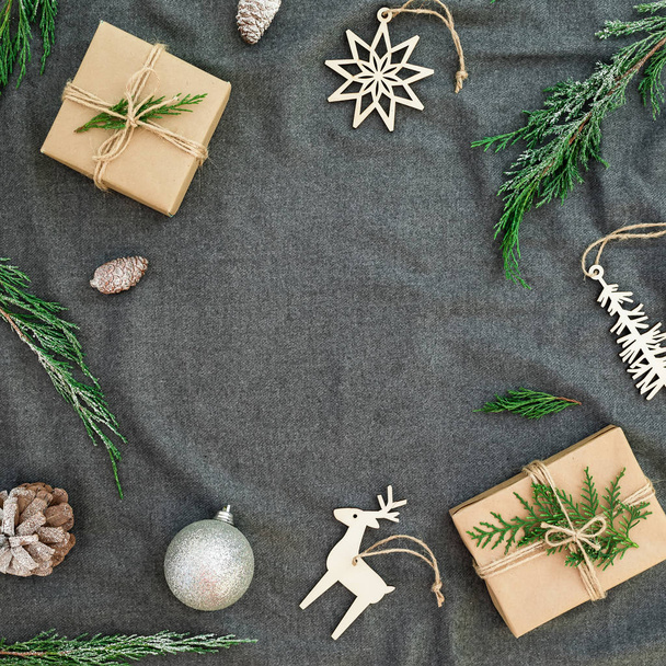 New Year, winter frame concept. Christmas decorations with evergreen tree branches and gifts on cloth background. Flat lay, top view. - Valokuva, kuva