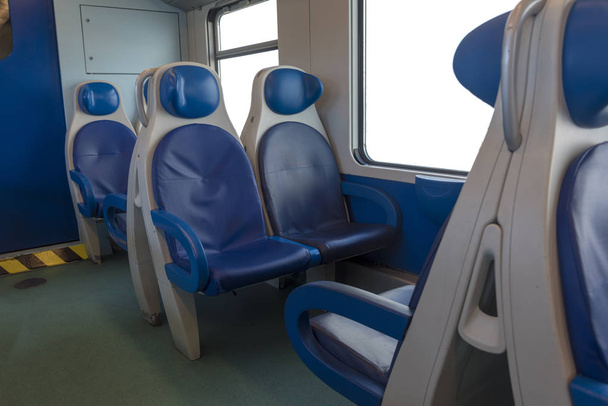 Inside the cab of the modern Express. Nobody in blue chairs by the window. Fuzziness. Comfortable chairs and table in the foreground, white background outside the window. Travelling to Spain, Europe. - 写真・画像