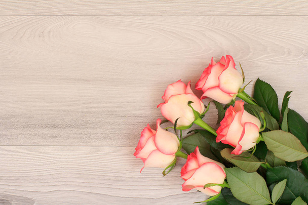 Beautiful bouquet of pink roses on gray wooden background. Top view with copy space. - Фото, изображение