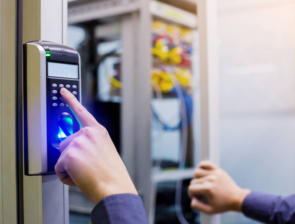 Staff push down electronic control machine with finger scan to access the door of control room or data center. The concept of data security or data access control. - Foto, imagen