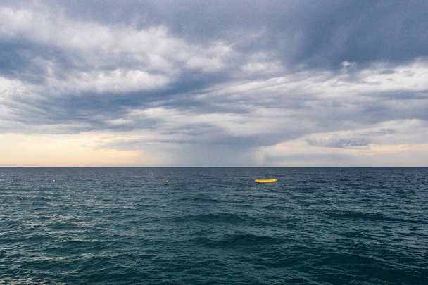 Paysage marin avec bateau jaune solitaire et ciel orageux sur la mer
 - Photo, image