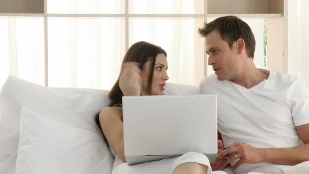 Couple using a laptop in the bedroom - Záběry, video