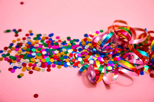holiday colorful ribbons with confetti on pink background, close-up  - Fotó, kép