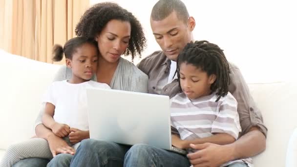 Afro-American family using a laptop in the living-room - Кадри, відео