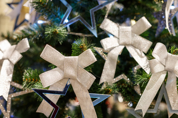 Árbol de Navidad con arcos brillantes. Concepto Año Nuevo fondo celebración. Foto de primer plano del árbol de Navidad decorado con arcos brillantes
 - Foto, imagen