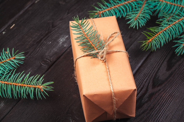 Christmas gift boxes and fir tree branch on wooden table. - Photo, image