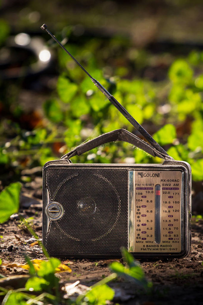 Παλιά ραδιοφωνικός δέκτης στο γρασίδι. - Φωτογραφία, εικόνα