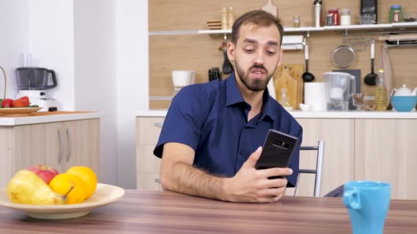 Man in the kitchen talking with somebody on the phone - Séquence, vidéo