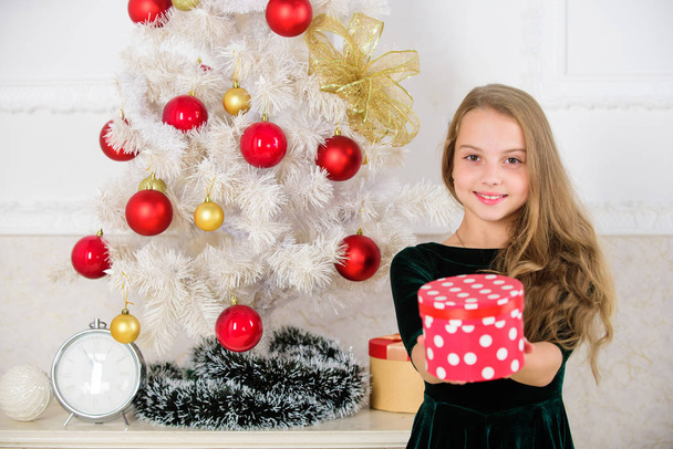 Dreams come true. Best for our kids. Kid girl near christmas tree hold gift box. Child celebrate christmas at home. Favorite day of the year. Time to open christmas gifts. Opening christmas presents - Zdjęcie, obraz