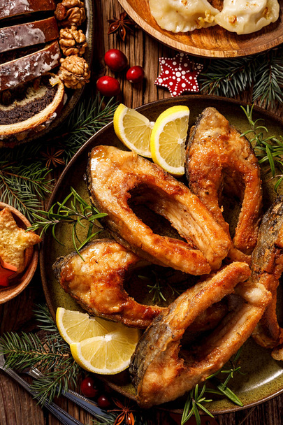 Carpa de Navidad, rebanadas de pescado frito en un plato de cerámica, de cerca, vista superior. Plato tradicional de Nochebuena. Navidad polaca
 - Foto, imagen