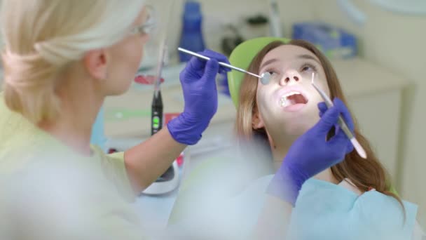 Teeth treatment process in dentist office. Blonde dentist working with patient - Footage, Video