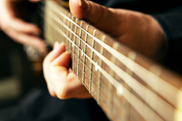 Close-up fingerboard of an electric guitar in the hands of a musician. - Foto, immagini