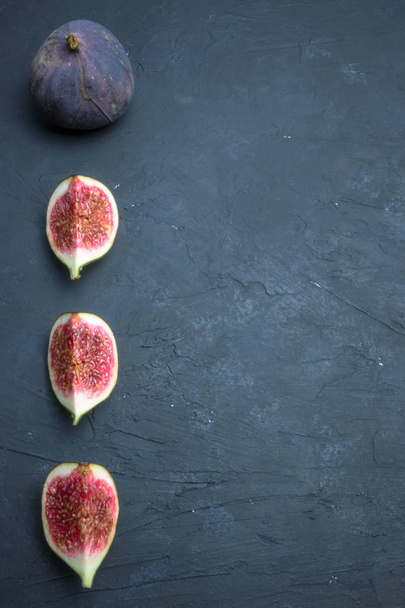 Fresh figs. Food photography. Creative scheme of whole and sliced figs on a dark background, inscribed in a rectangle. Copy space - Photo, image