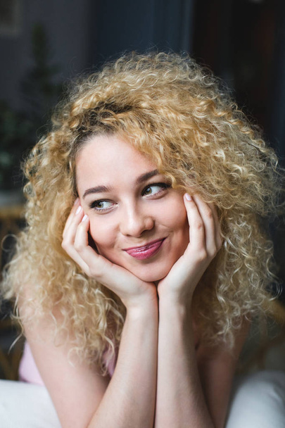 Portrait of young charming smiling girl with curly hair. Hairstyle. - Фото, зображення