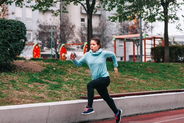 Woman running. Female runner jogging, training for marathon. Fit girl fitness athlete model exercising outdoor. - Photo, Image