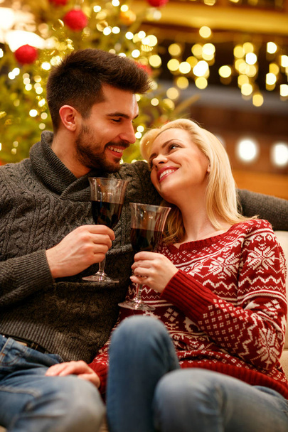 Christmas holiday - romantic smiling couple toasting with red win - 写真・画像