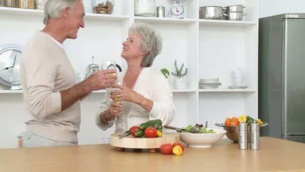 Mutfakta salata hazırlama ve şarap içmeye gülümseyen kıdemli çift yüksek çözünürlüklü görüntüleri - Video, Çekim