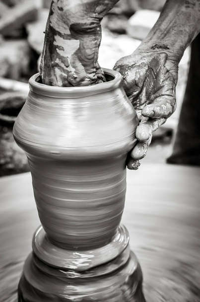 Manos de un hombre creando cerámica en la rueda, vista de estilo vintage monocromo
 - Foto, Imagen